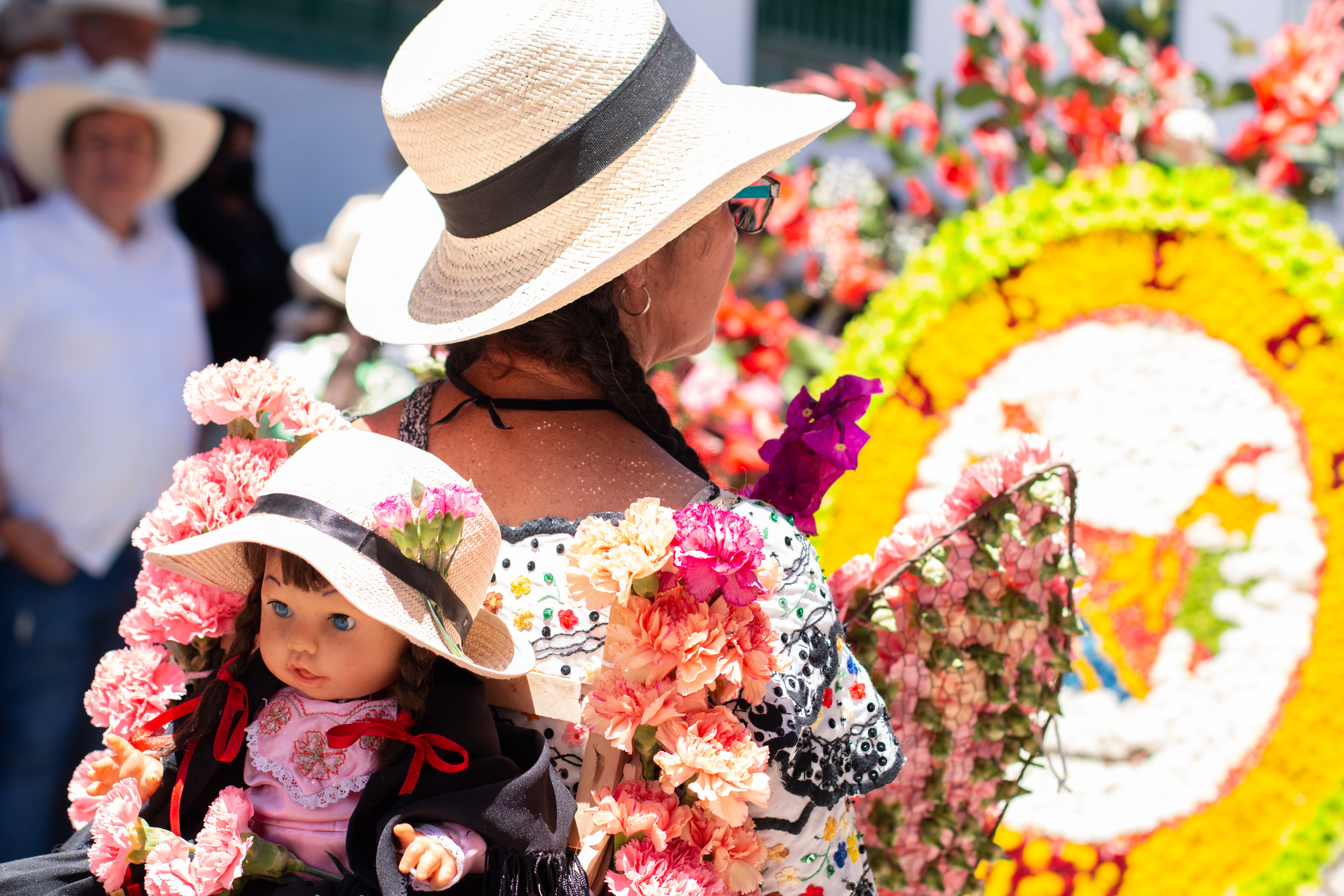 Woman seen from the back with hat and typical costume of Colombian culture at the flower festival.